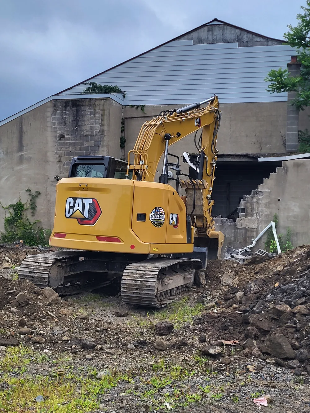 Excelsior Earthworks excavator working beside a building on a demolition site