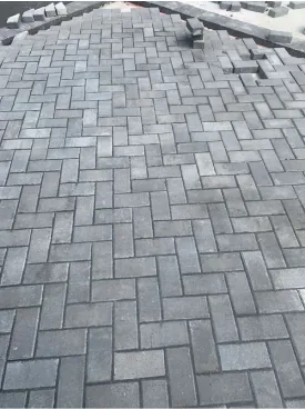 Gray paver driveway laid in a herringbone pattern